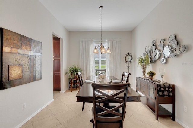 dining area with light tile patterned flooring and an inviting chandelier