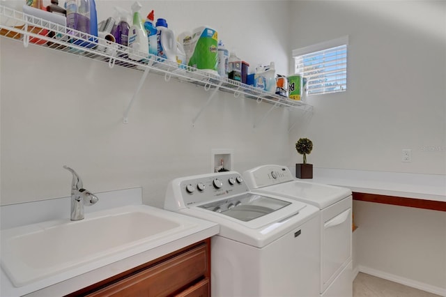 clothes washing area with cabinets, washer and dryer, and sink