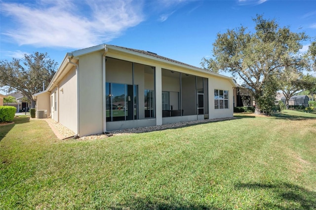 back of property with a lawn and central AC unit