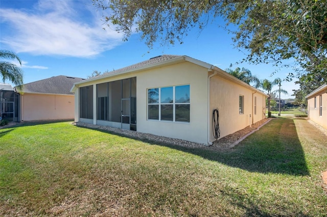 back of property featuring a lawn and a sunroom