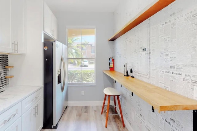 kitchen featuring light wood-type flooring, white cabinets, wood counters, and stainless steel fridge with ice dispenser