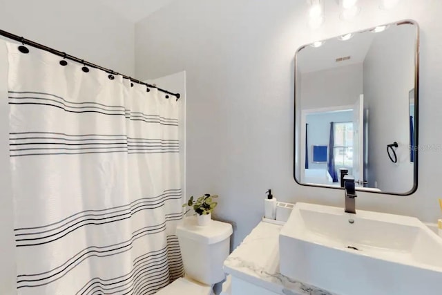 bathroom with vanity, toilet, and curtained shower