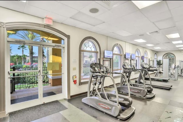 gym with a drop ceiling and french doors