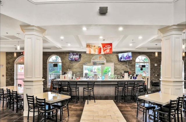 dining space featuring indoor bar and ornate columns