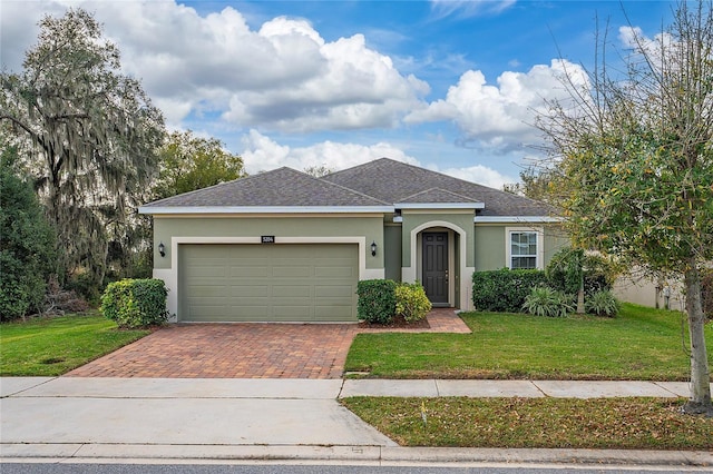 single story home featuring a garage and a front lawn