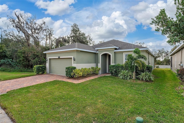 ranch-style house featuring a garage and a front lawn