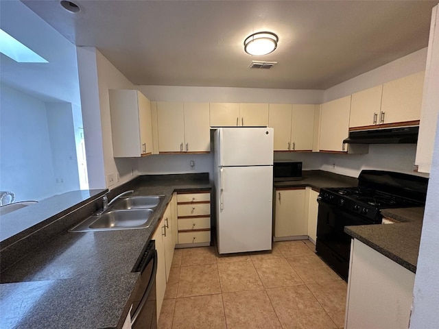 kitchen featuring light tile patterned floors, a skylight, sink, and black appliances