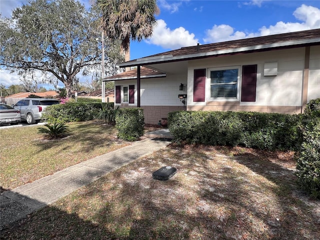 view of front of home featuring concrete block siding and a front yard