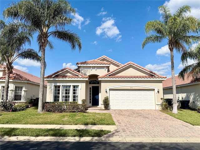 mediterranean / spanish home with a garage and a front yard