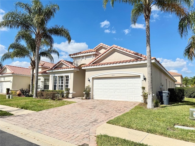 mediterranean / spanish-style house featuring a garage and a front yard