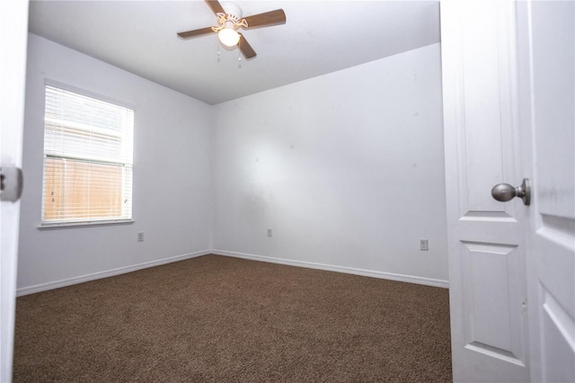 empty room with ceiling fan and dark carpet