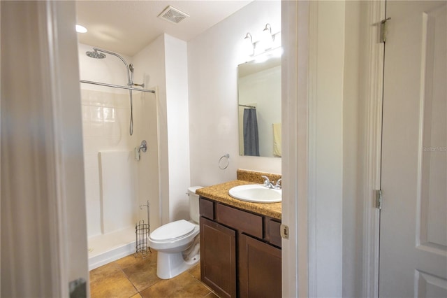 bathroom with tile patterned flooring, walk in shower, vanity, and toilet