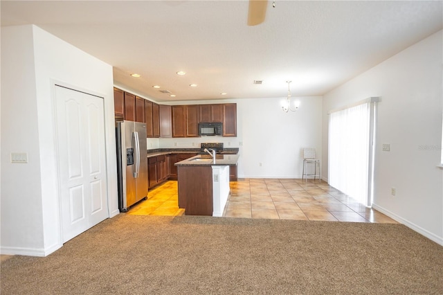 kitchen featuring sink, stainless steel refrigerator with ice dispenser, an island with sink, decorative light fixtures, and light colored carpet