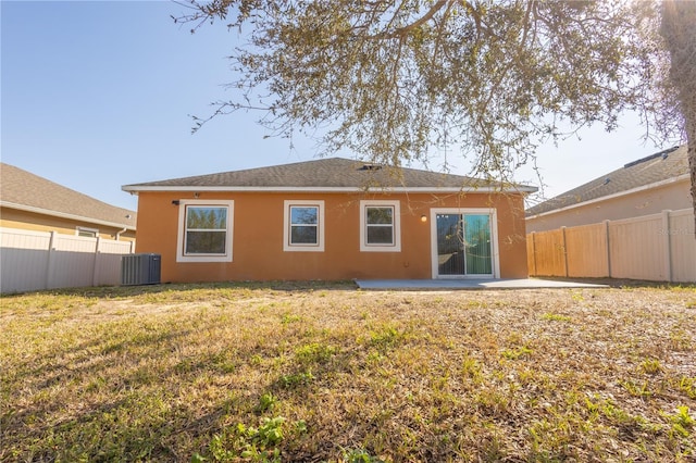 rear view of property featuring a patio, a yard, and central AC unit