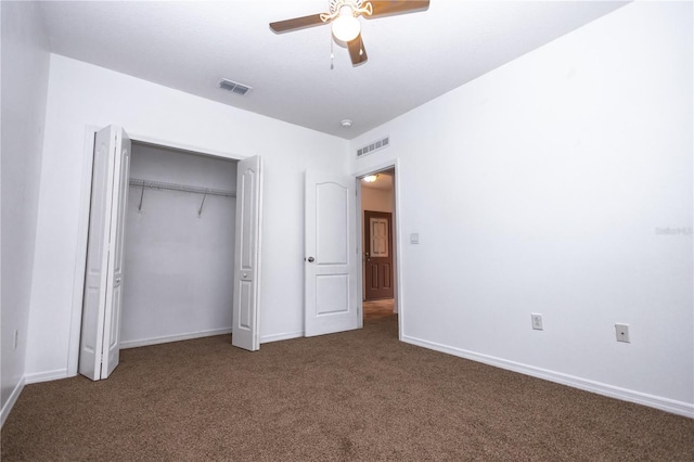 unfurnished bedroom featuring ceiling fan, dark carpet, and a closet