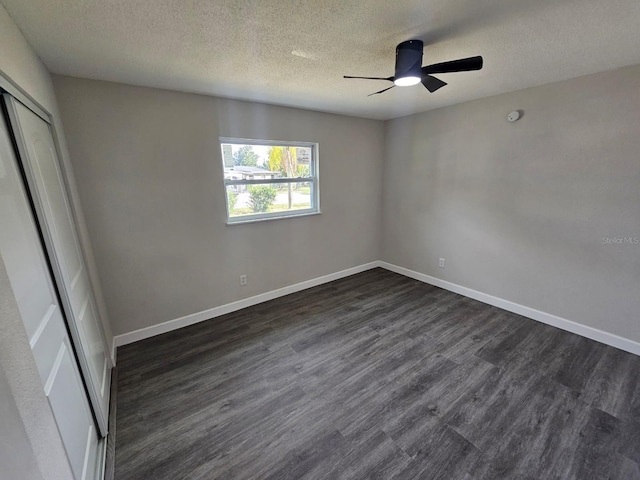 unfurnished bedroom featuring dark wood-type flooring, ceiling fan, a closet, and a textured ceiling