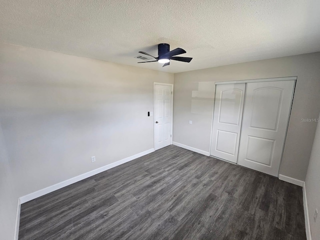 unfurnished bedroom with dark wood-type flooring, a closet, and a textured ceiling