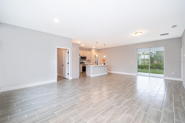 unfurnished living room featuring sink