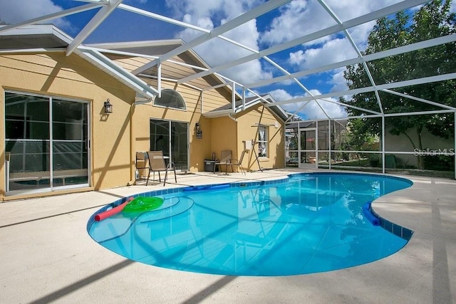 view of pool with a patio and glass enclosure