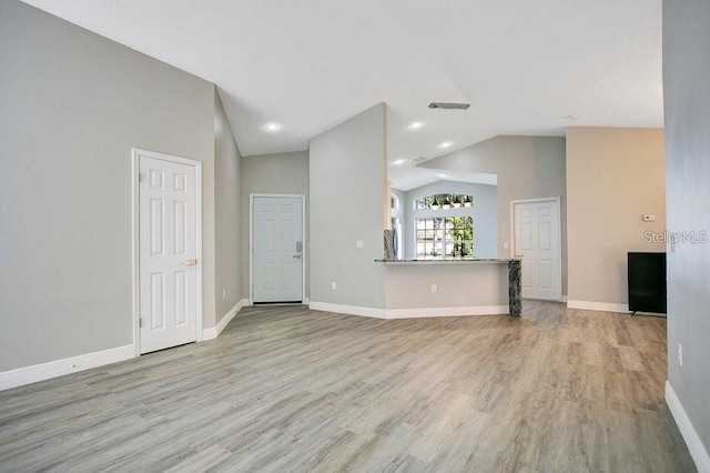 unfurnished living room with high vaulted ceiling and light hardwood / wood-style flooring