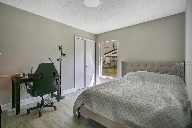 bedroom with hardwood / wood-style floors, a closet, and a textured ceiling