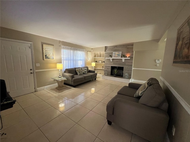 living room featuring light tile patterned floors, built in shelves, and a tile fireplace