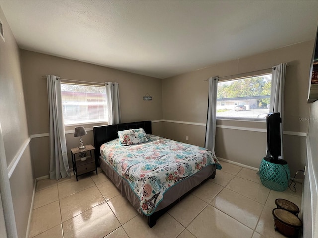 tiled bedroom with multiple windows