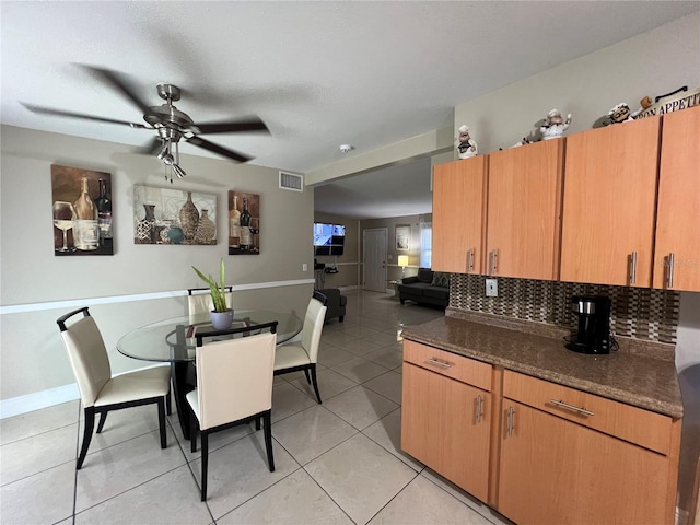 tiled dining space featuring ceiling fan