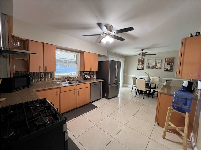 kitchen featuring tasteful backsplash, sink, light tile patterned floors, and black appliances