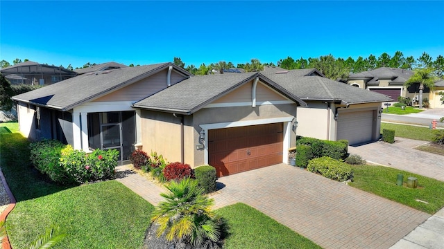 view of front facade with decorative driveway, an attached garage, a residential view, and a front yard