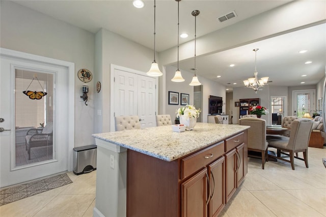 kitchen featuring a center island, decorative light fixtures, light tile patterned floors, visible vents, and open floor plan