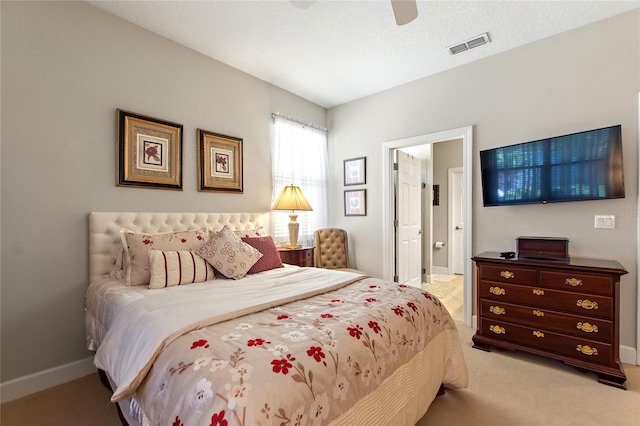 bedroom featuring visible vents, a ceiling fan, light carpet, connected bathroom, and baseboards