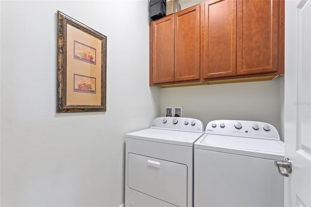 washroom featuring independent washer and dryer and cabinet space