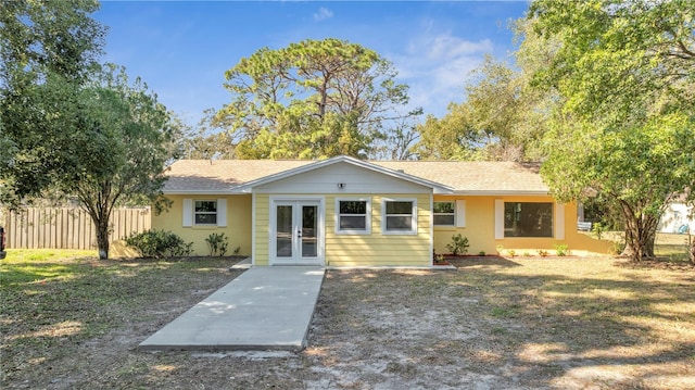 view of front of home with french doors and a front lawn