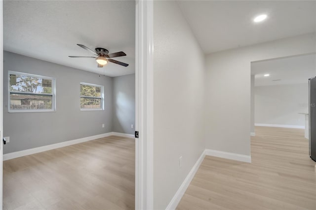 hallway featuring a textured ceiling and light wood-type flooring