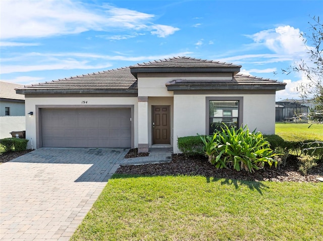 view of front facade with a front lawn, decorative driveway, an attached garage, and stucco siding