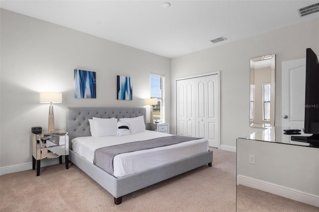 bedroom featuring light colored carpet, a closet, visible vents, and multiple windows