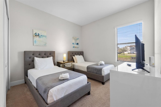 bedroom with light carpet and baseboards