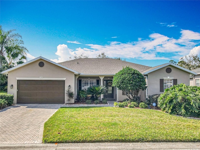 single story home with a garage and a front lawn