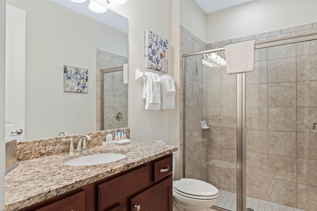 bathroom with vanity, toilet, and a shower with door