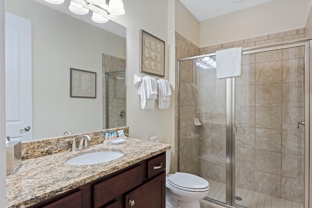 bathroom with vanity, a shower with shower door, and toilet