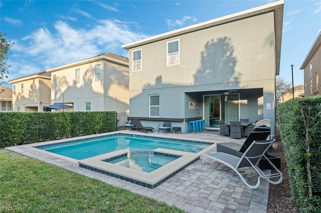 back of house with ceiling fan, a pool with hot tub, and a patio area