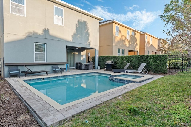 view of swimming pool with an in ground hot tub, a patio, grilling area, and a lawn