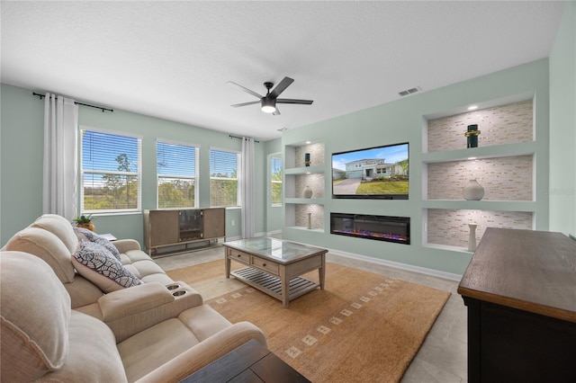 139 Aces High Ln, Davenport, FL 33896 - tiled living room featuring visible vents, a ceiling fan, a glass covered fireplace, and built in shelves