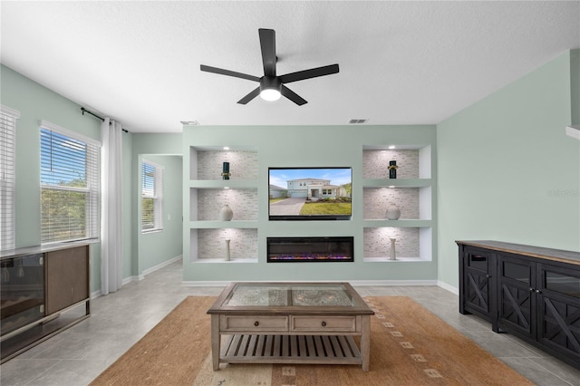 139 Aces High Ln, Davenport, FL 33896 - living area featuring tile patterned floors, visible vents, a ceiling fan, and a glass covered fireplace