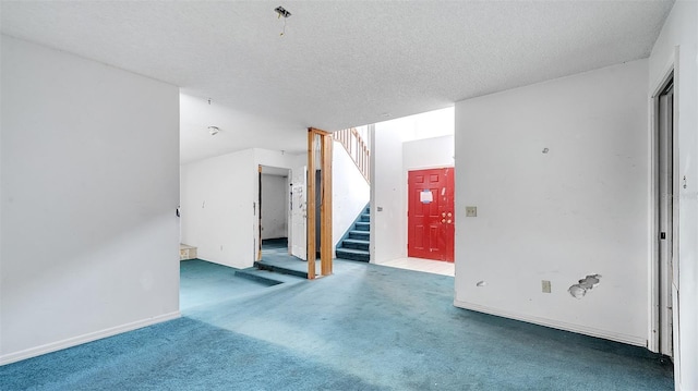 carpeted spare room featuring a textured ceiling