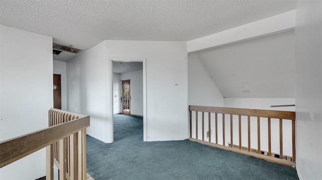 hallway featuring a textured ceiling and dark colored carpet