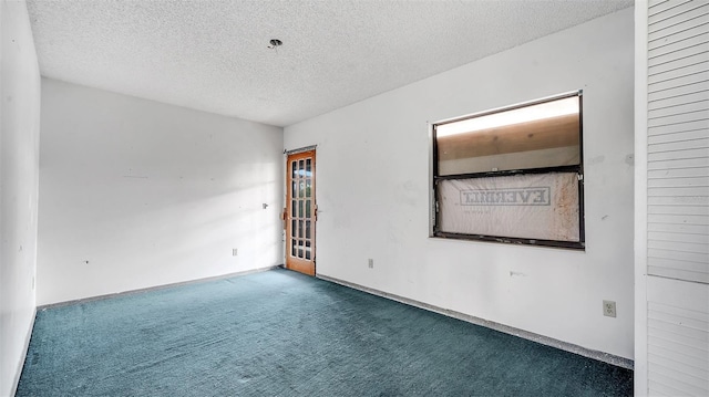 spare room featuring carpet floors and a textured ceiling