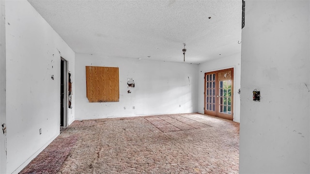 spare room with a textured ceiling and carpet flooring
