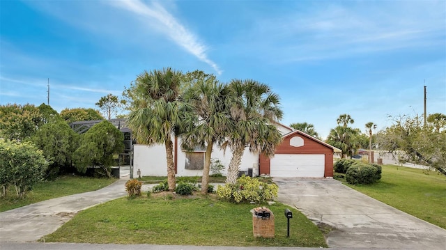 view of property hidden behind natural elements with a garage and a front lawn